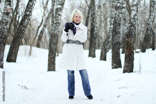 Young woman photographer on winter background © Andrey_Arkusha