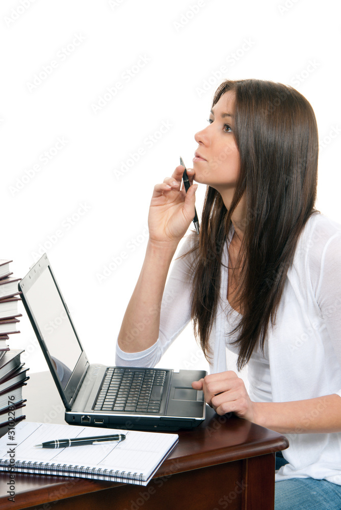 Woman sitting with laptop with pen in hand
