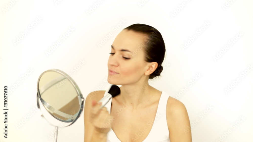 Beautiful woman applying natural beauty make-up in the mirror Beautiful woman applying natural beauty make-up in the mirror