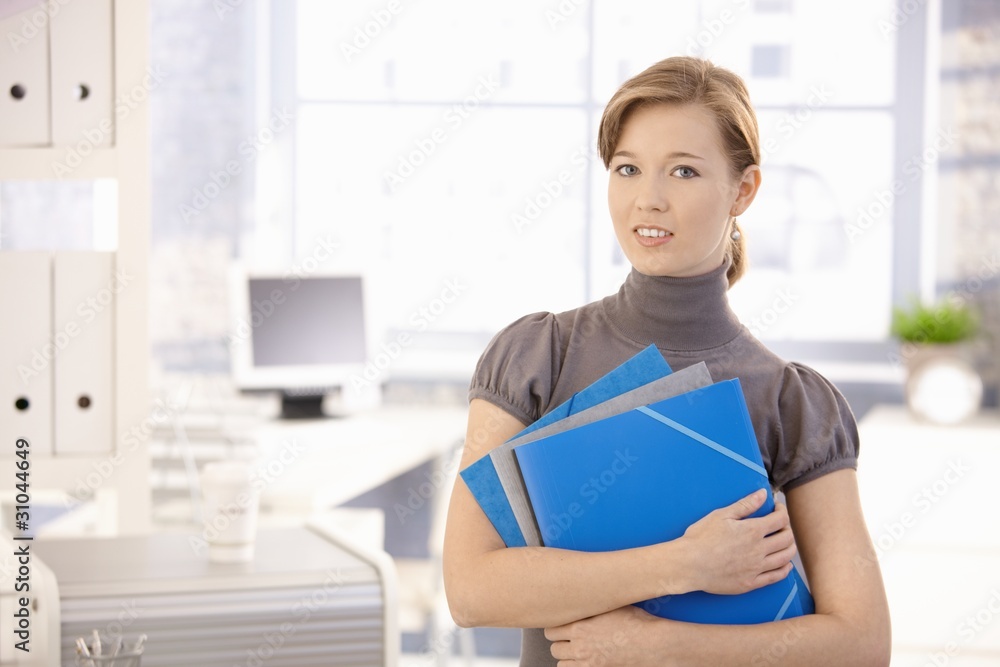 Young woman with folders in office Young woman with folders in office