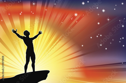 Man on cliff top with arms raised