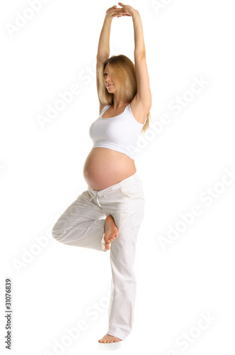 Pregnant woman practicing yoga, standing