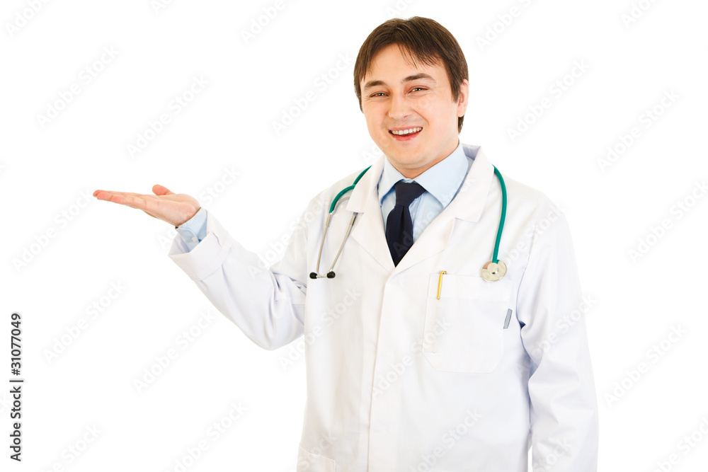 Smiling medical doctor presenting something on empty hand Smiling medical doctor presenting something on empty hand