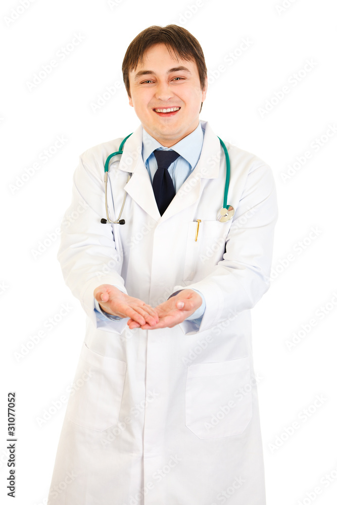 Smiling medical doctor presenting something on empty hands Smiling medical doctor presenting something on empty hands