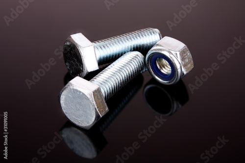 Screw and bolt with reflection on grey background