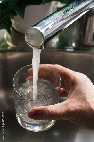 Takiing a glass of water from a faucet