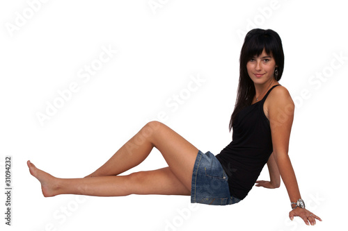 Woman sitting on the floor, full body shot