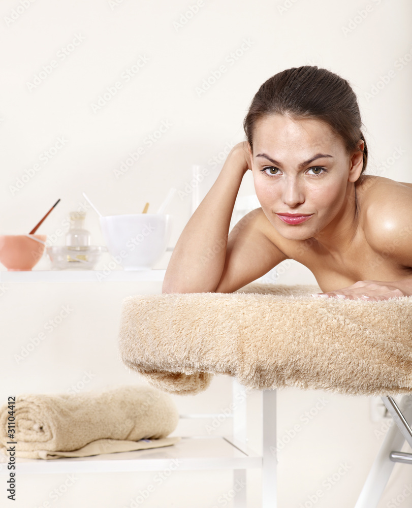 Naklejka premium Young woman on massage table in beauty spa.