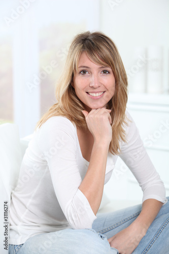 Portrait of beautiful blond woman sitting in sofa