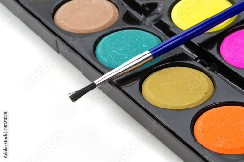 Closeup of a palette of watercolor paints with brush.