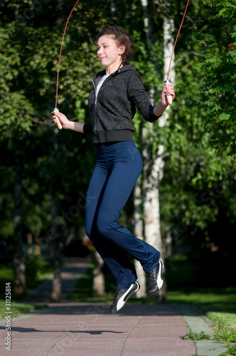 Jumping woman with skipping rope at park