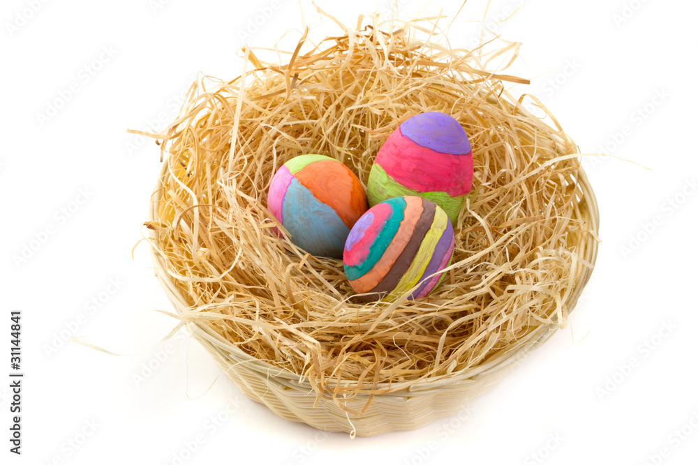 Colorful Easter eggs on hay in the basket Colorful Easter eggs on hay in the basket
