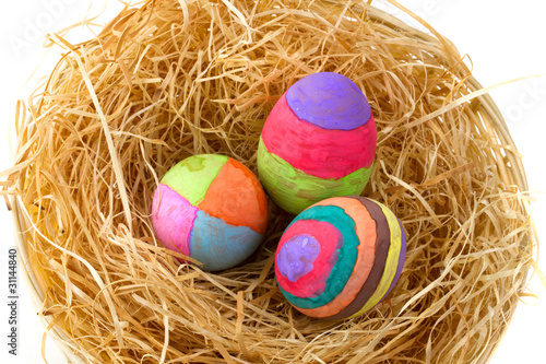 Colorful Easter eggs on hay in the basket