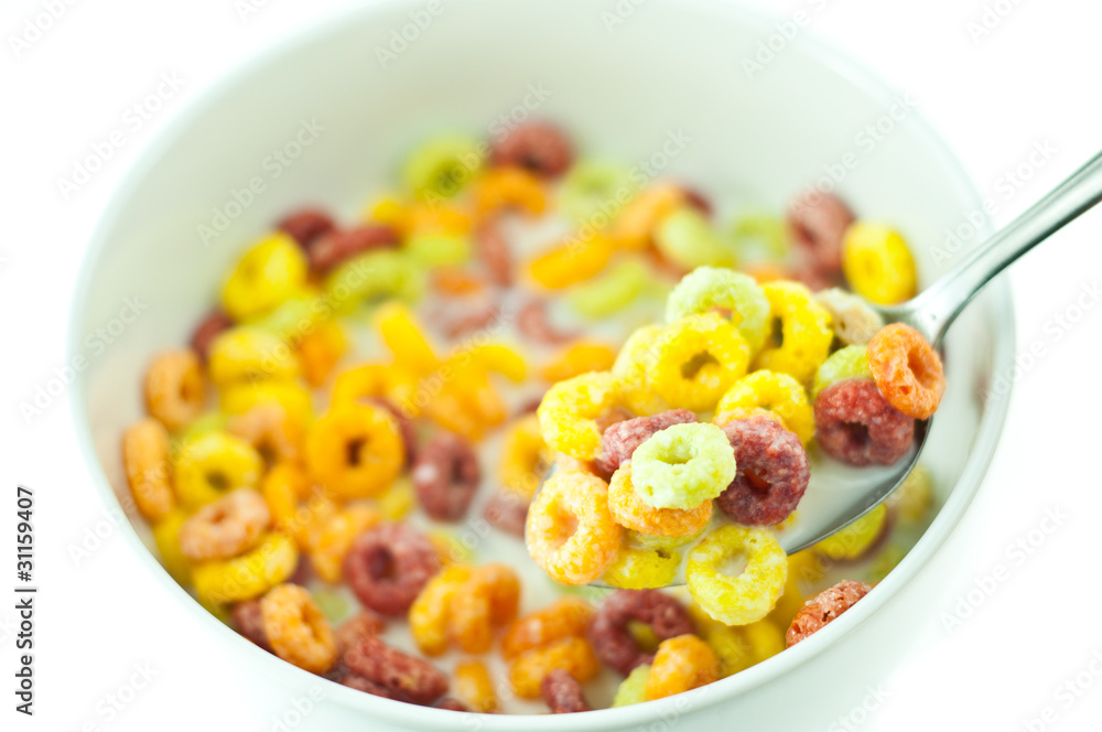 Bowl and spoon with corn flakes on the white background Bowl and spoon with corn flakes on the white background