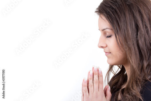 Beautiful teenage girl praying isolated on white background