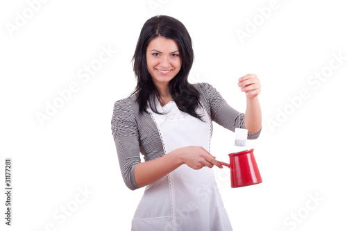 Attractive teenage girl smiling and preparing a tea isolated