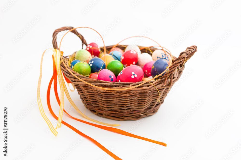 Geflochtener Korb gefüllt mit vielen bunten Eiern für Ostern