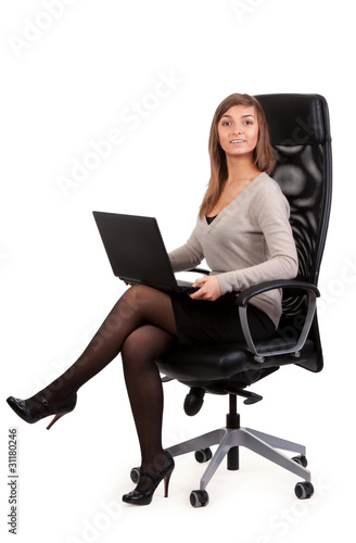 Young business lady in a chair with a laptop