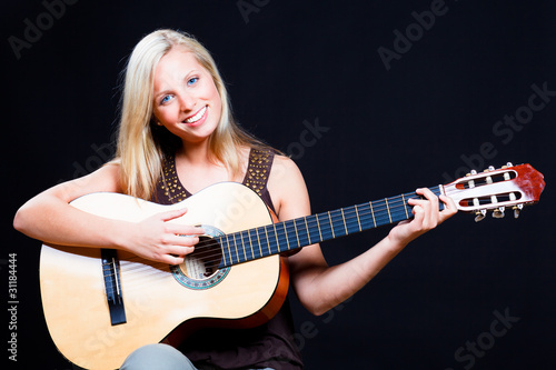 fröhliche junge frau spielt gitarre