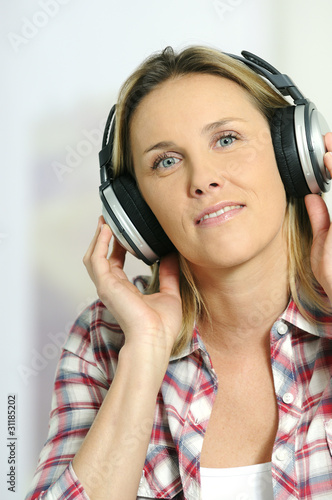 blond woman relaxing at home, listening music photo