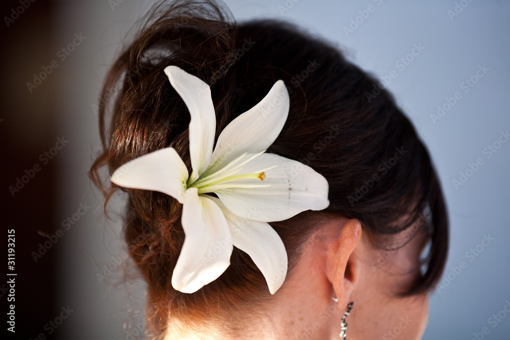 Naklejka premium white lily flower in brown up do hair