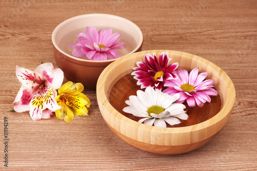Pink and white flowers floating in bowl