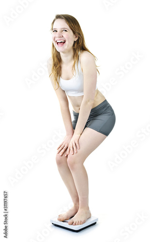 Excited fit young girl on bathroom scale