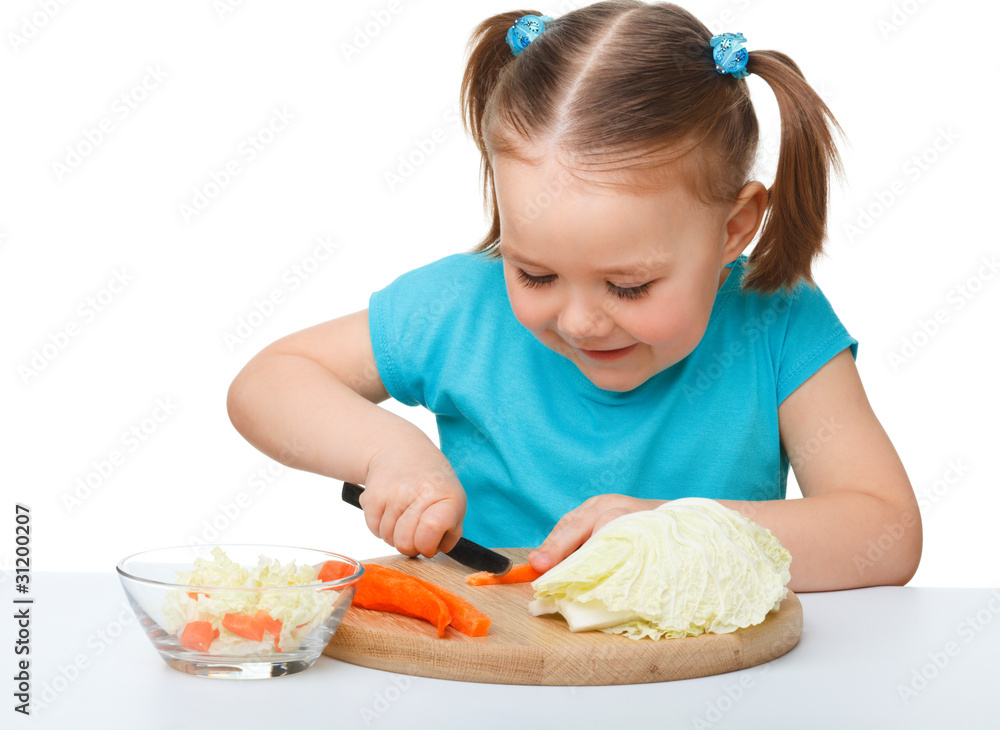 Little girl is cutting carrot for salad Little girl is cutting carrot for salad