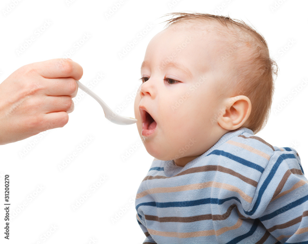 Cute little boy is being fed using spoon Cute little boy is being fed using spoon