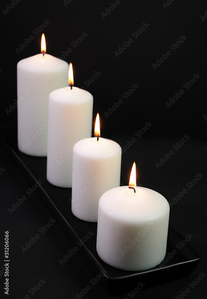 White decoration candles on black background White decoration candles on black background