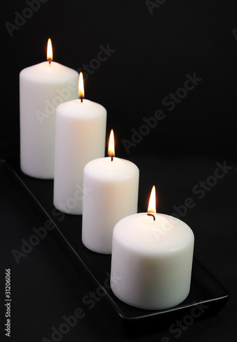 White decoration candles on black background