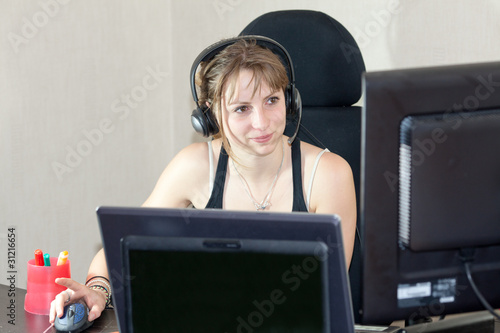 girl with headphone playing on computer or talking skype msn