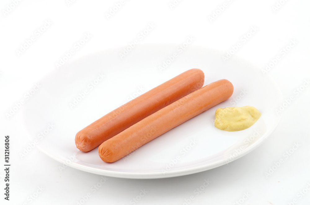 deux saucisses et de la moutarde dans un plat deux saucisses et de la moutarde dans un plat