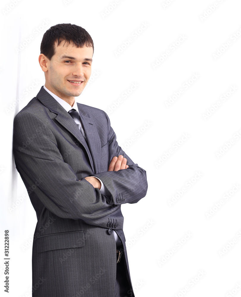 Businessman standing against a blank gray wall. Businessman standing against a blank gray wall.