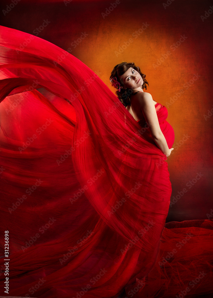Pregnant woman in red flying waving dress. Pregnant woman in red flying waving dress.