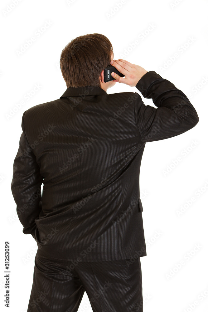 Businessman standing back to camera and talking on phone Businessman standing back to camera and talking on phone