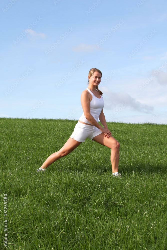 Beautiful woman doing fitness exercises in nature