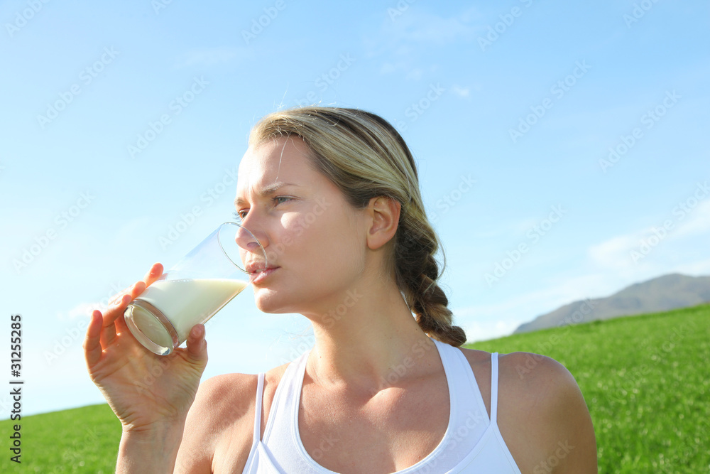 Beautiful blond woman drinking milk in countryside Beautiful blond woman drinking milk in countryside
