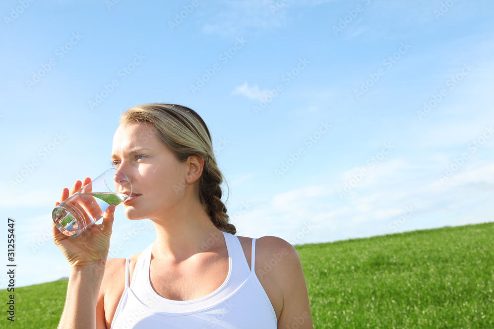 Woman drinking natural water in green field Woman drinking natural water in green field