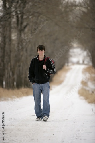 A Teenage Boy Walking On A Snow-Covered Path © Vibe Images