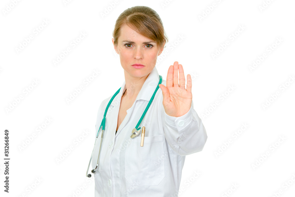 Strict medical female doctor showing stop gesture isolated Strict medical female doctor showing stop gesture isolated