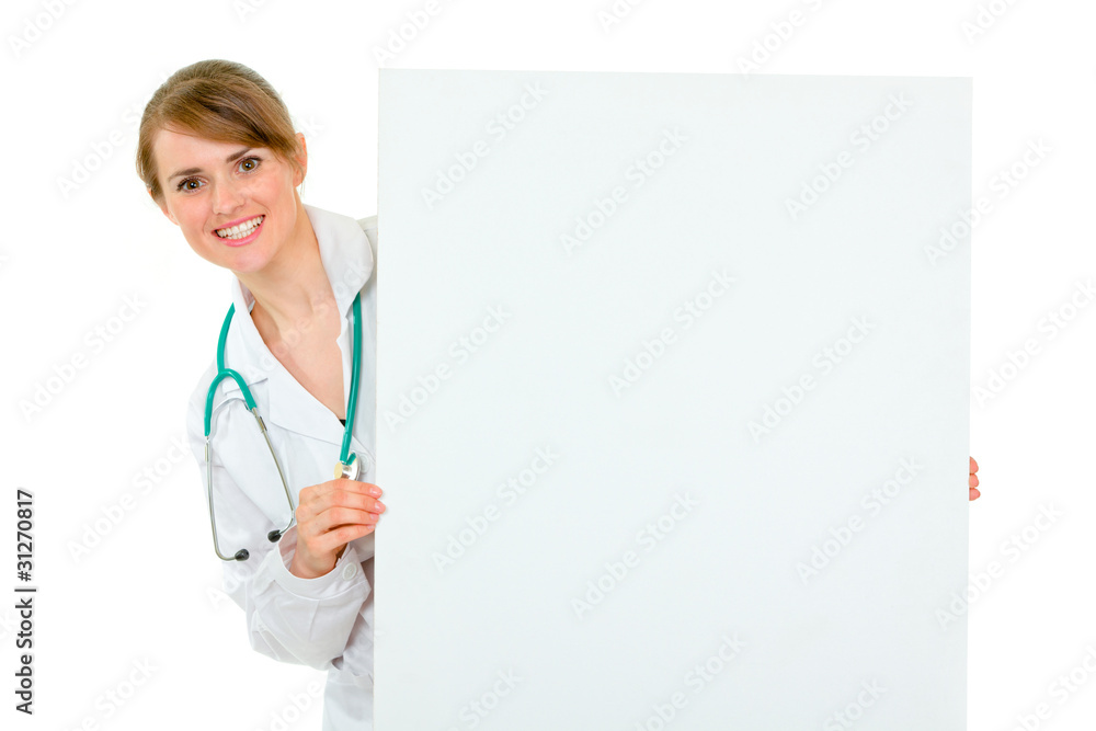 Smiling medical doctor woman holding blank billboard Smiling medical doctor woman holding blank billboard