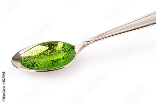 Green cough syrup in silver spoon