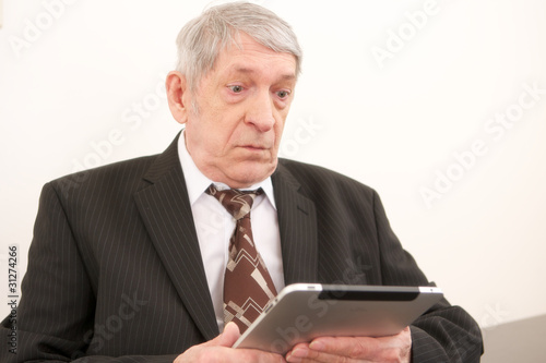 Rentner arbeitet mit einem moderne Tablett computer