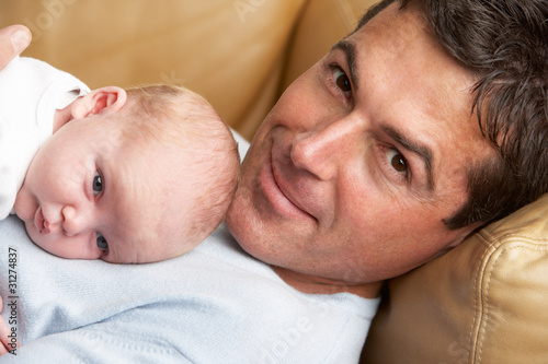 Portrait Of Father With Newborn Baby At Home