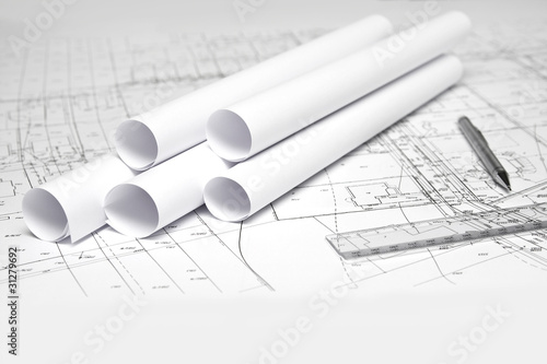 ołówek i rulony na białym planie budowy architektonicznym