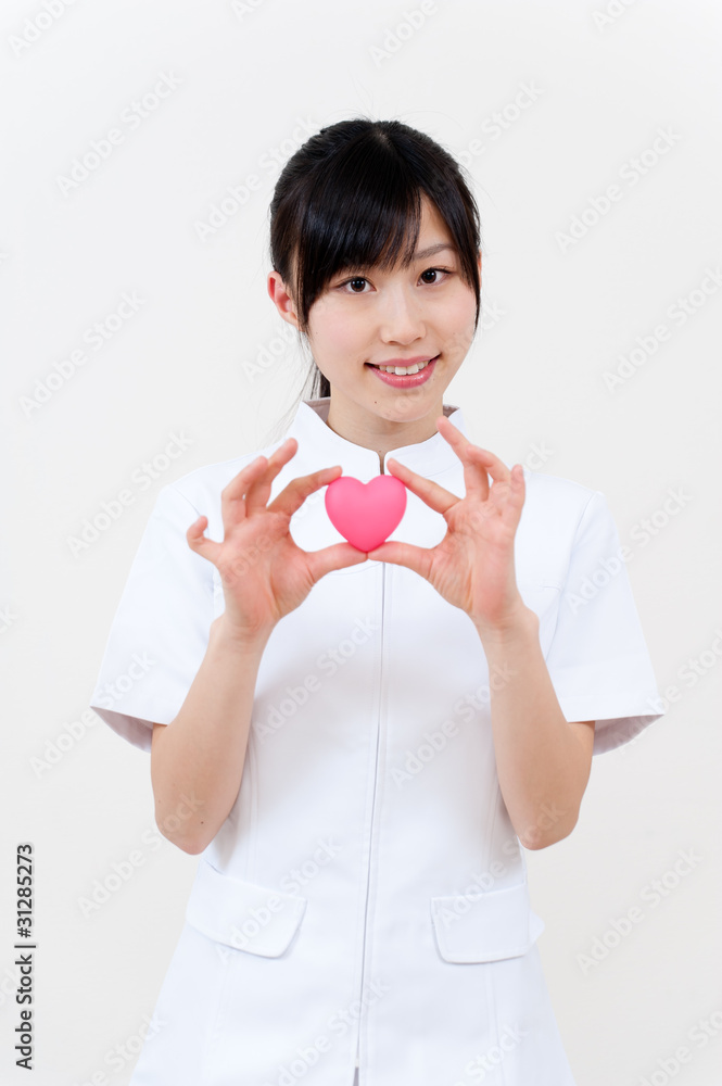 beautiful asian nurse holidng a symbol of heart