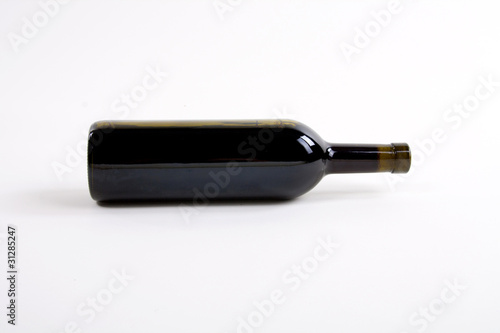 close-up of red wine bottle over white