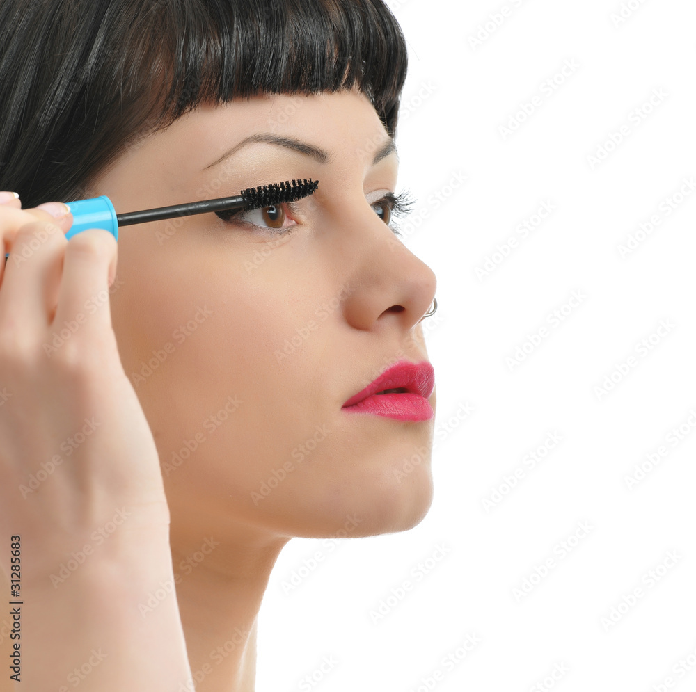 closeup of a pretty girl applying mascara