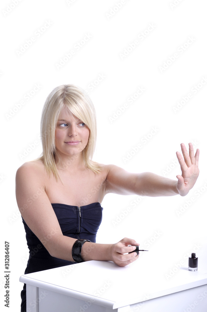 young woman looking at her varnished nails young woman looking at her varnished nails